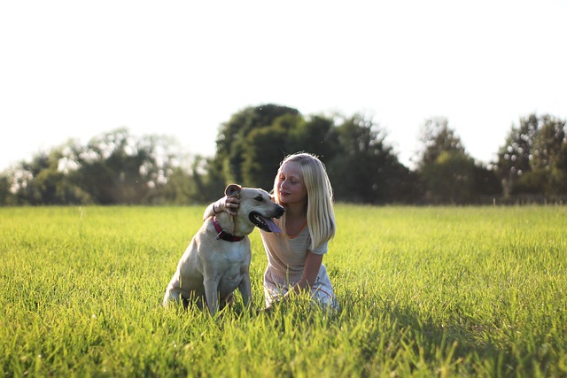 a girl and her dog sitting in the grass