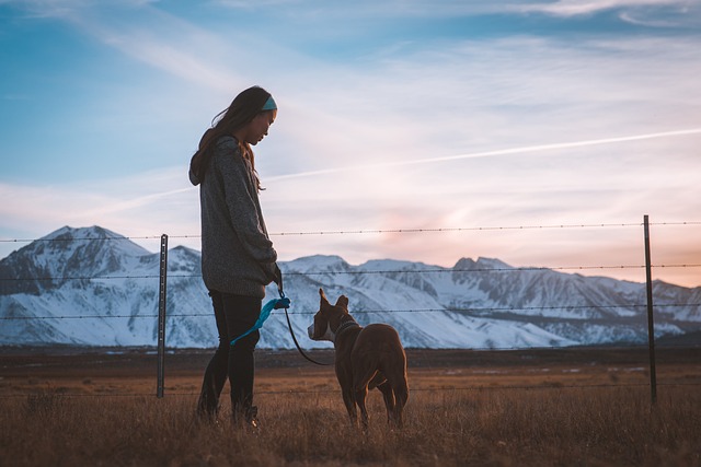 a woman and her dog next to a mountain