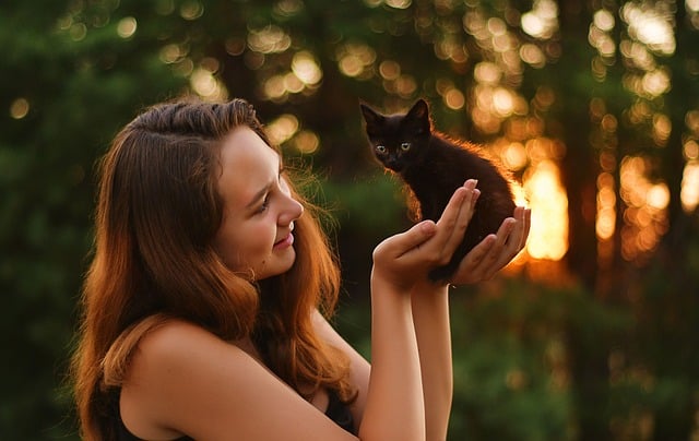 a girl holding a kitten in her hands