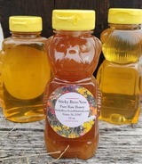 three jars of honey on a wooden surface